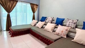 A hotel room with a large bed, a sofa bed, a ceiling fan, and a window with curtains. - Animation Homes I Meru Raya IPOH I by Grab A Stay l 16pax max (Ipoh)