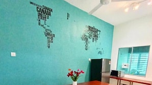 A dining area with a teal wall, a wooden table, and four chairs. - Animation Homes I Meru Raya IPOH I by Grab A Stay l 16pax max (Ipoh)
