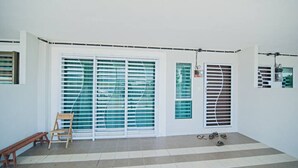 A room with a bench, a chair, and a pair of shoes on the floor. - Animation Homes I Meru Raya IPOH I by Grab A Stay l 16pax max (Ipoh)