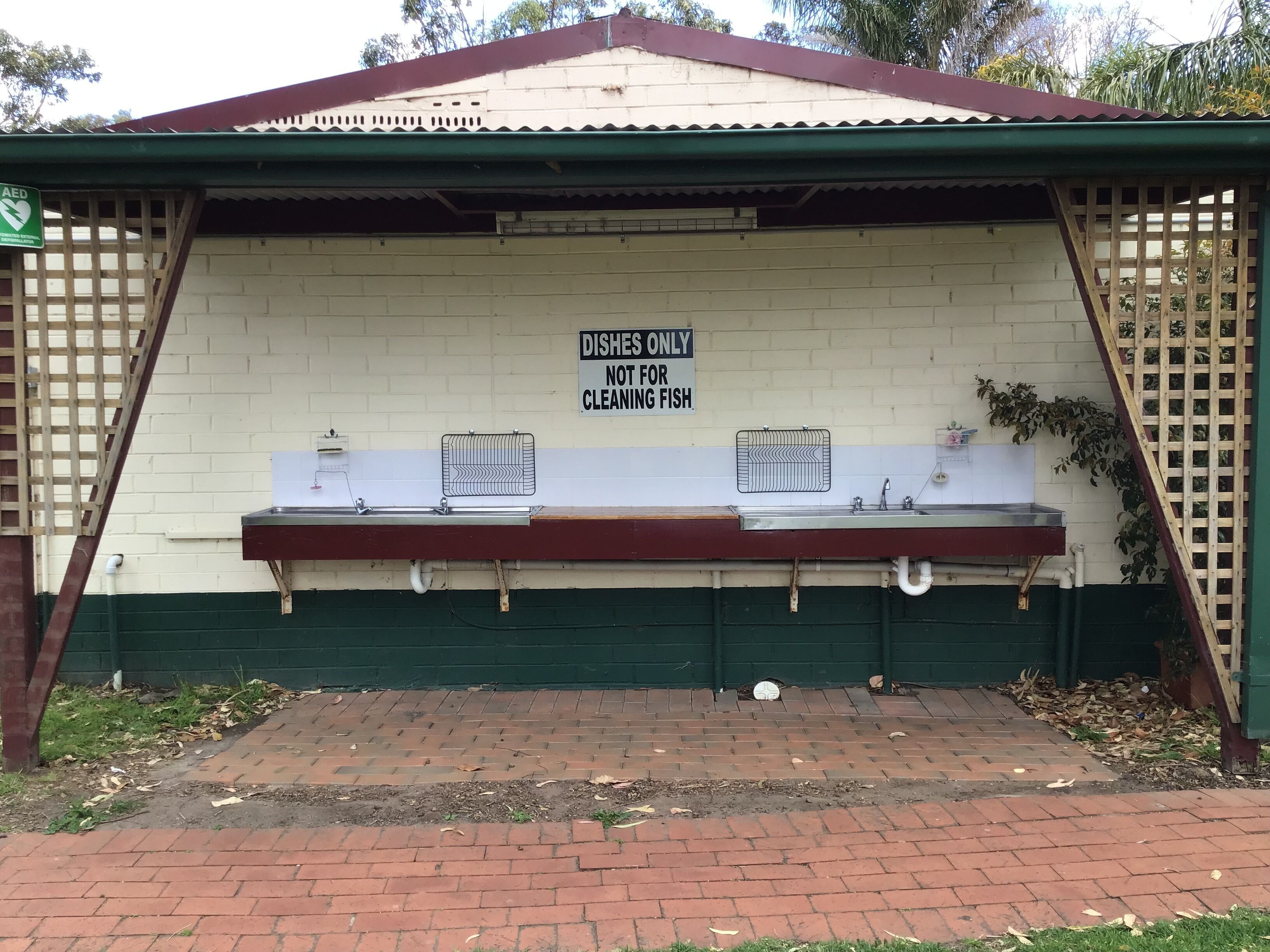 A public restroom with a sign indicating it's for cleaning fish, not for dishes.
