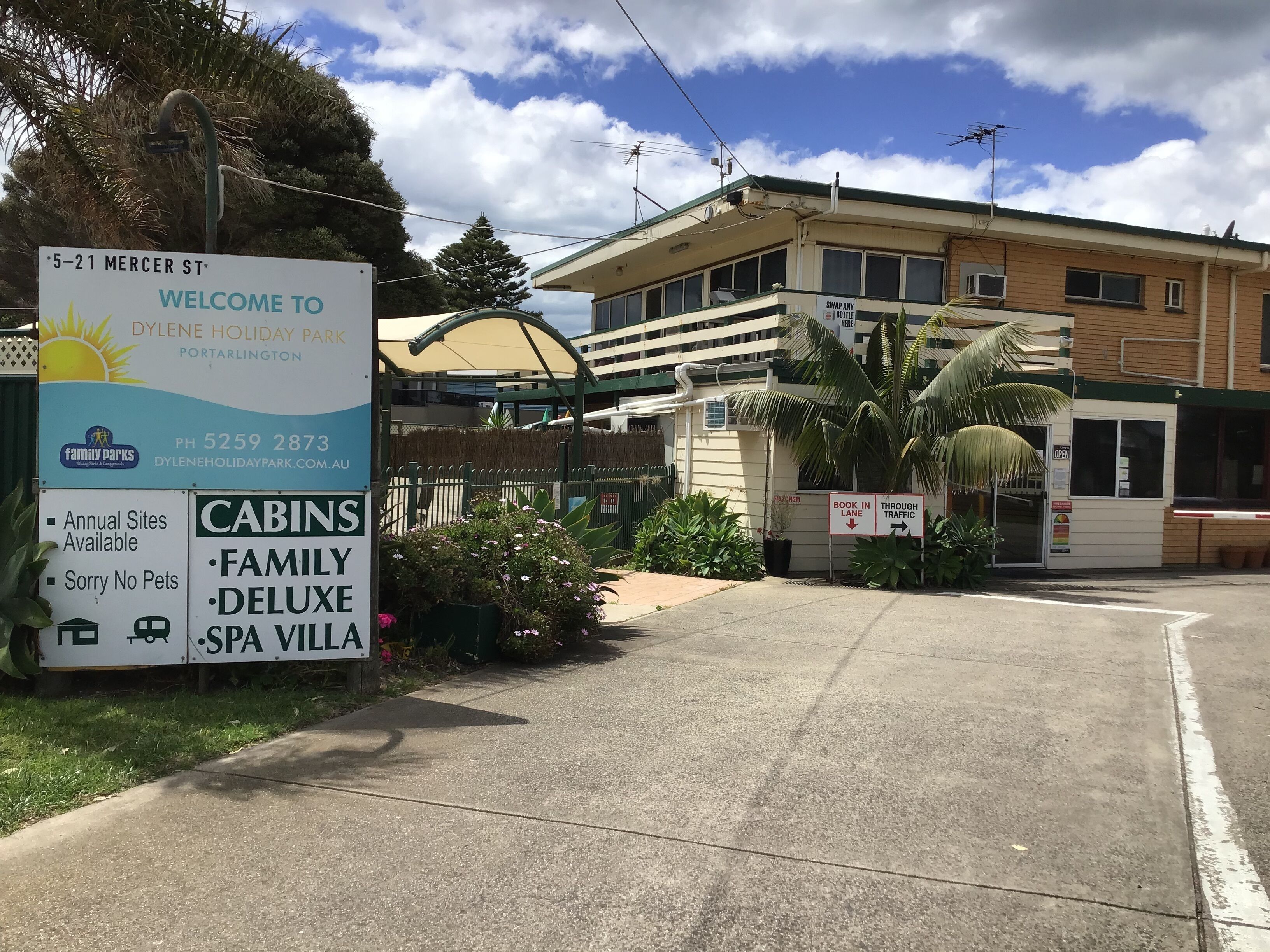 A sign for Dylen Holiday Park with information on cabins, family deluxe, and spa villa.