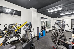 A gym with various exercise equipment, including treadmills, stationary bikes, and weight machines.