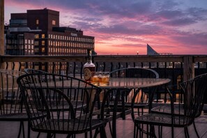 A rooftop terrace with a table set for two, a bottle of liquor, and glasses. - Historic Levy Penthouse Downtown Louisville (Louisville)