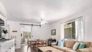 Et moderne interiør med spiseplads, en sofa og et køkken.
