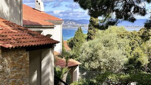 Ein Gebäude aus Stein mit Ziegeldach, das auf eine Küstenlandschaft blickt.