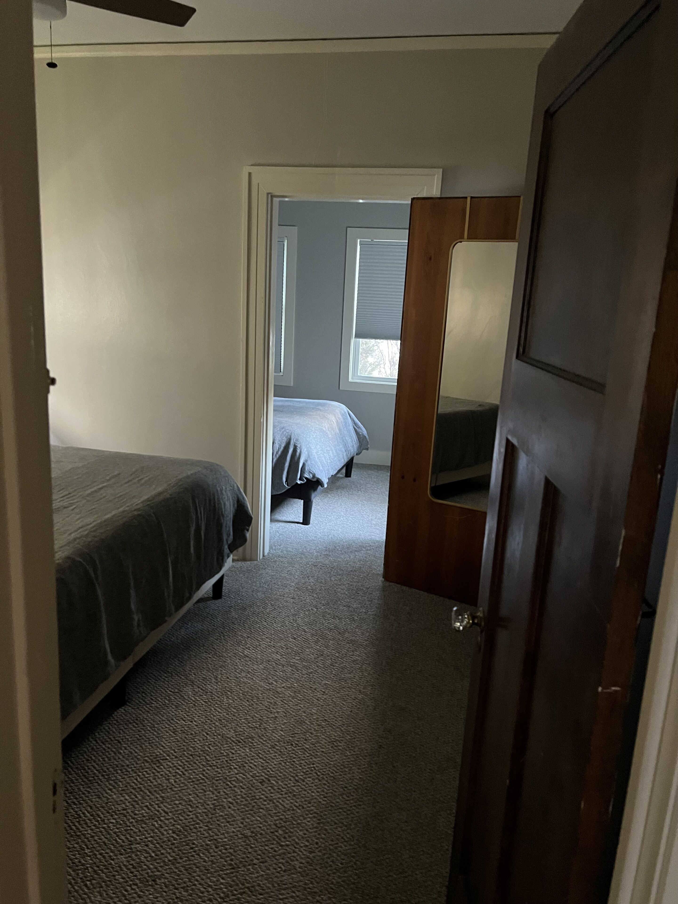 Un dormitorio con cama, ventana y puerta.