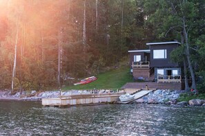 A lakeside cabin with a dock, a boat, and a forested backdrop. - Stay North - Villa Kalksved (Sipoo)