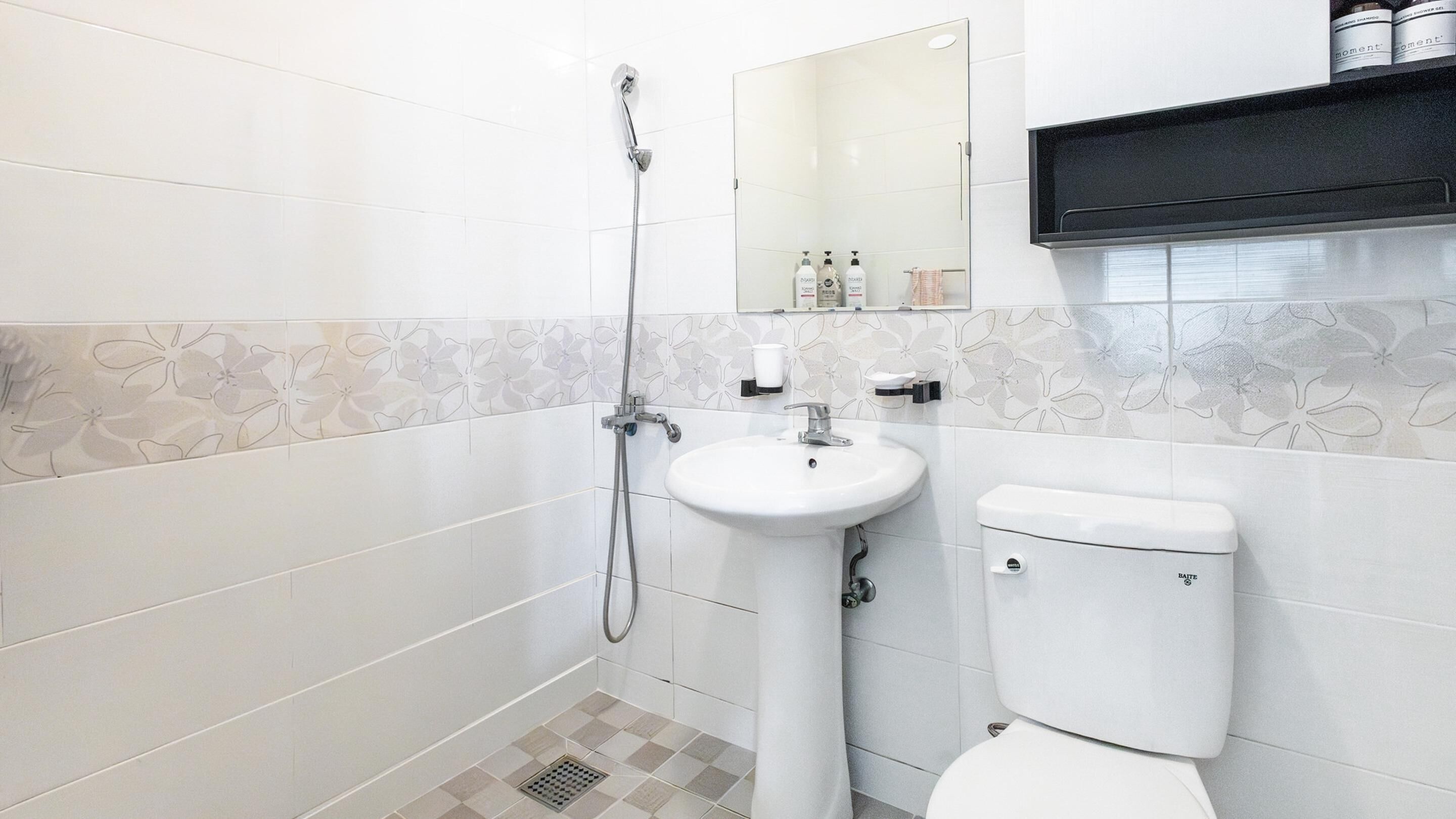 Un baño con ducha, lavabo e inodoro.