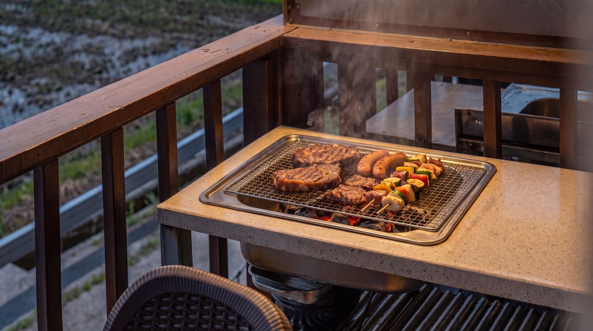 Una parrilla con filetes, salchichas y verduras en un balcón.
