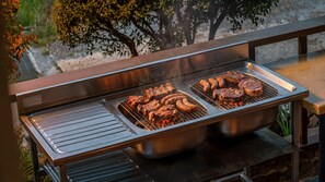 An outdoor grill with meats and sausages being cooked. - Suncheon Romance Pension (Suncheon)