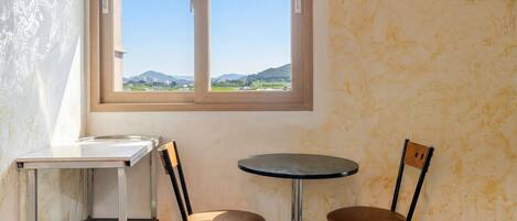 A small room with a window, a table, and two chairs.