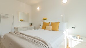 A modern bedroom with a large bed, bedside table, and a nightstand with a lamp. - Ponente Balcony in Gravedona (Gravedona)