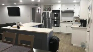 A modern kitchen with white cabinets, stainless steel appliances, and a central island. - Awesome Pool House in the Kern River Valley (Wofford Heights)