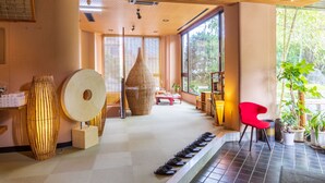 A traditional Japanese room with tatami flooring, a red chair, and a row of shoes. - Oyado Uoki (Yugawara)