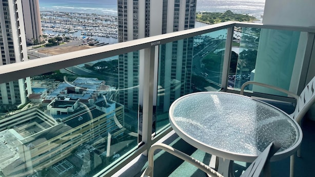 A high-rise building with a glass balcony overlooking a marina and cityscape. - Last Minute Spacial! Oceanview's on 31st Flr (Honolulu)