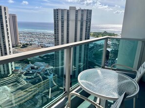 A high-rise building with a glass balcony overlooking a marina and cityscape. - Last Minute Spacial! Oceanview's on 31st Flr (Honolulu)