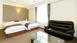 A hotel room with two beds, a leather sofa, a glass coffee table, and a large window with curtains. - BEPPU KANKO HOTEL ACE (Beppu)