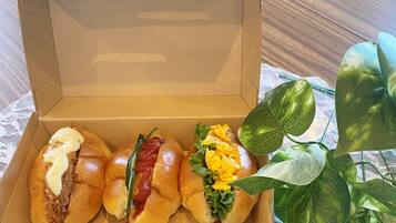 An open cardboard box containing three different types of sandwiches.