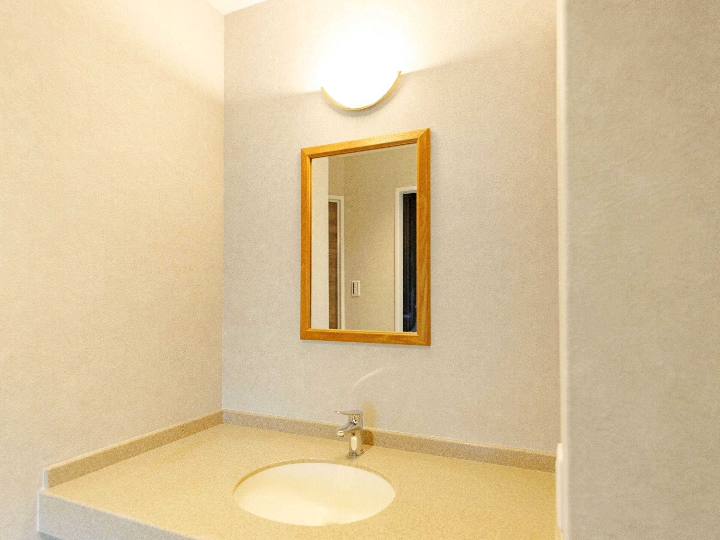 Ein Badezimmer mit Waschbecken, Spiegel und Lampenleuchte.