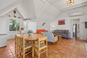 Un loft amplio con comedor, sofá y televisor.