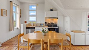 A kitchen with a dining table, chairs, and a window.