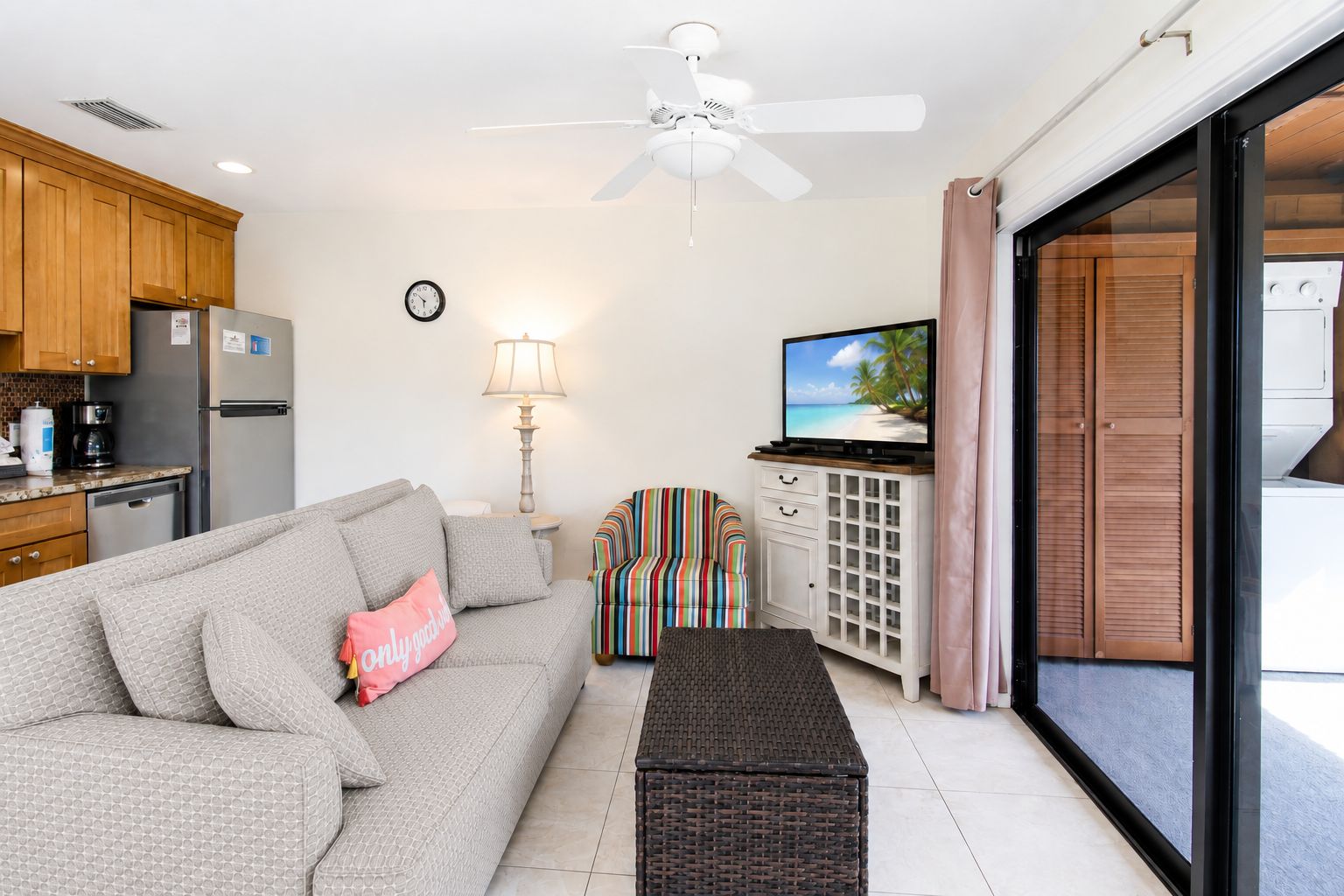 Una sala moderna con un sofá, televisor, comedor y cocina.