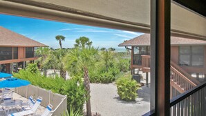 Vista de un patio de hotel con asientos al aire libre, palmeras y cielo despejado.