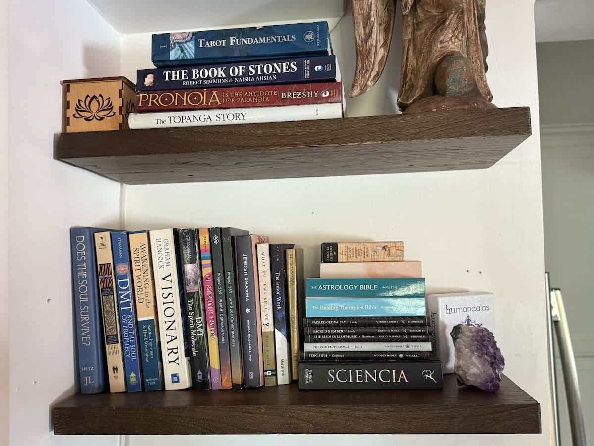 Ein Bücherregal mit verschiedenen Büchern und einem Kristall.