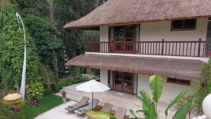 A two-story house with a thatched roof, a pool, and a balcony. - Kembali On The River by Balipras (Cepaka)