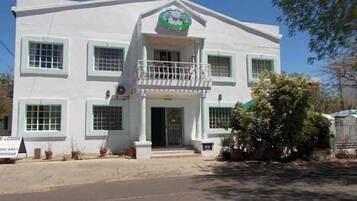 A two-story building with a balcony, a sign indicating it is a lodge, and a logo above the entrance.