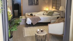 Een gezellige slaapkamer met een bed, een stoel, een klein tafeltje en een groot olifant schilderij aan de muur.