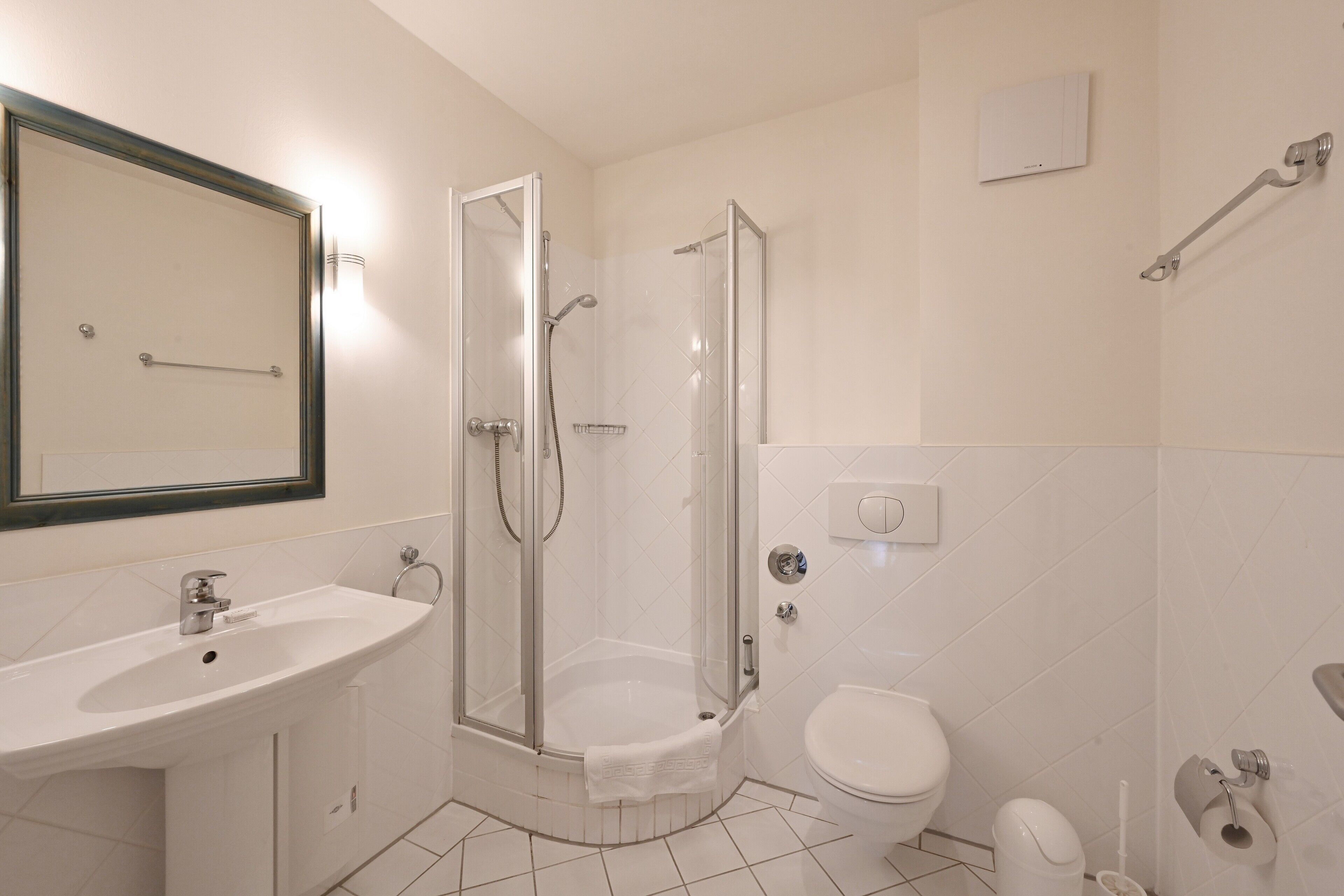 Ein Badezimmer mit Waschbecken, Toilette, Dusche und Spiegel.
