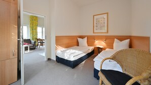 Une chambre d’hôtel avec un lit, une chaise, un bureau et une armoire.