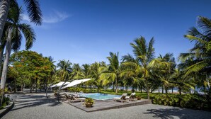 A poolside area with lounge chairs, a pool, and palm trees. - Anyu Hotel Sanya (Sanya)
