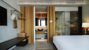 A modern hotel room with a large bed, a wooden vanity, a bathroom with a large mirror, and a shower area. - Anyu Hotel Sanya (Sanya)