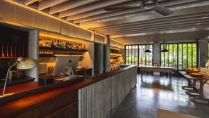 A modern bar area with a wooden counter, bar stools, and a variety of bottles. - Anyu Hotel Sanya (Sanya)