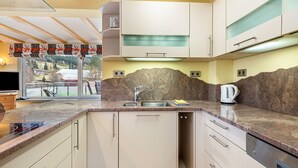 A modern kitchen with a granite countertop, stainless steel sink, and built-in appliances. - Holiday Home 'Ferienhaus Schwarzwälder Kirsch' with Private Terrace, Balcony and Wi-Fi (Feldberg)