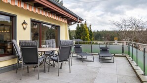 A patio with outdoor seating, a table, and a view of a lake. - Holiday Home 'Ferienhaus Schwarzwälder Kirsch' with Private Terrace, Balcony and Wi-Fi (Feldberg)