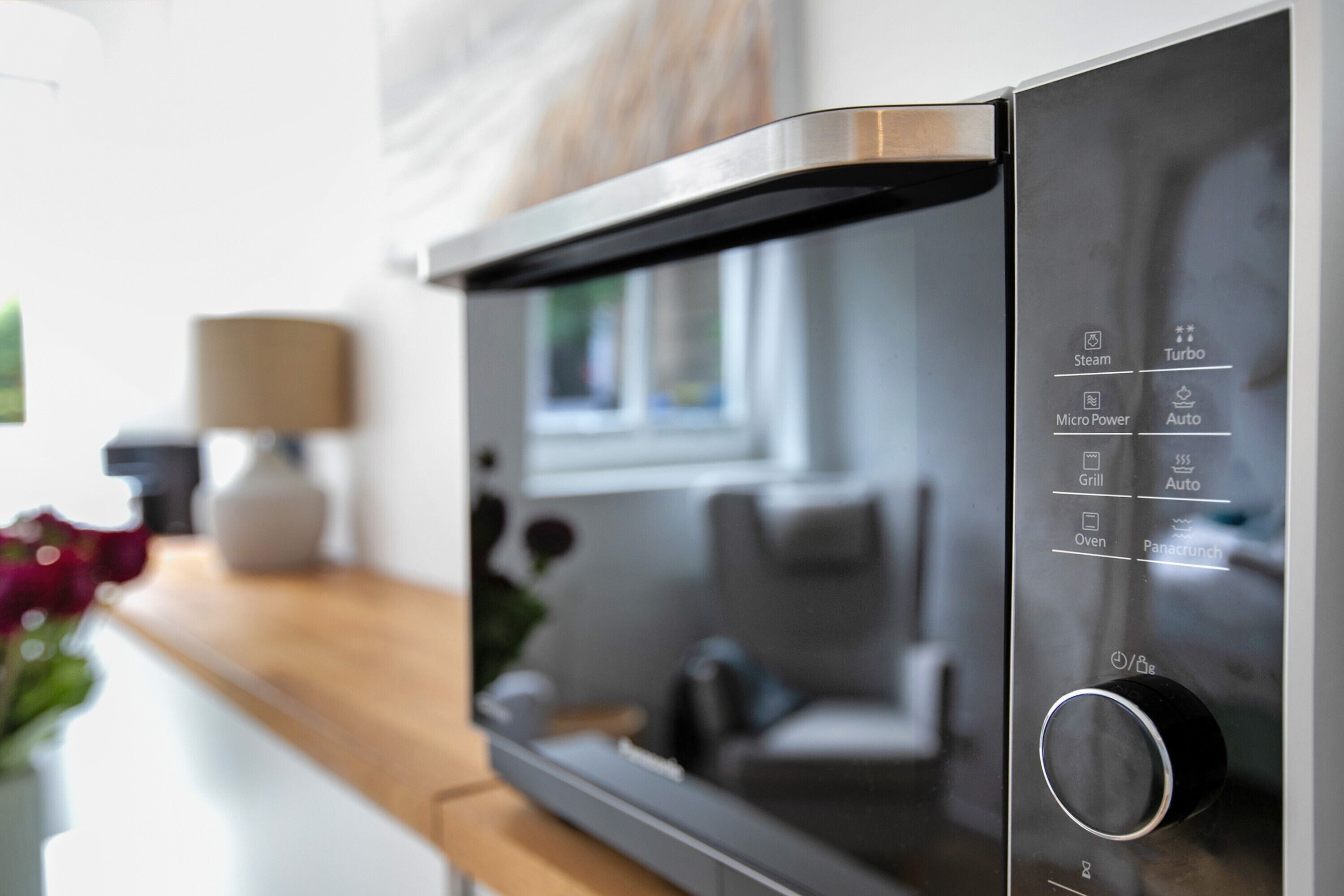 Une cuisine moderne équipée d’un four à micro-ondes, d’un four et d’un grill encastrés.