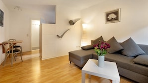 Een moderne woonkamer met een bank, een bijzettafeltje en een stoel.