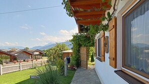 A house with a stone pathway, a wooden fence, and a view of mountains. - Apartment 'Haus Kali' with Mountain View, Shared Terrace and Wi-Fi (Teisendorf)