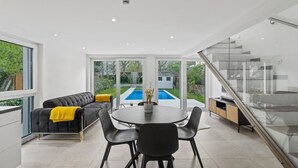 A modern kitchen with a dining area, large windows, and a view of a swimming pool. - Villa Jäger with Heated Pool (Available from 23.03.26) in Vienna, Private Terrace, Balcony, Wi-Fi (Wien)