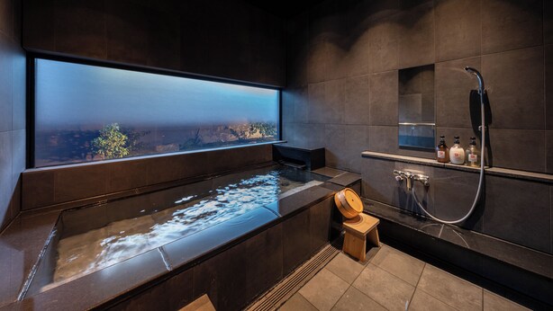 Un baño moderno con una bañera grande, ducha y ventana con vista a la ciudad.