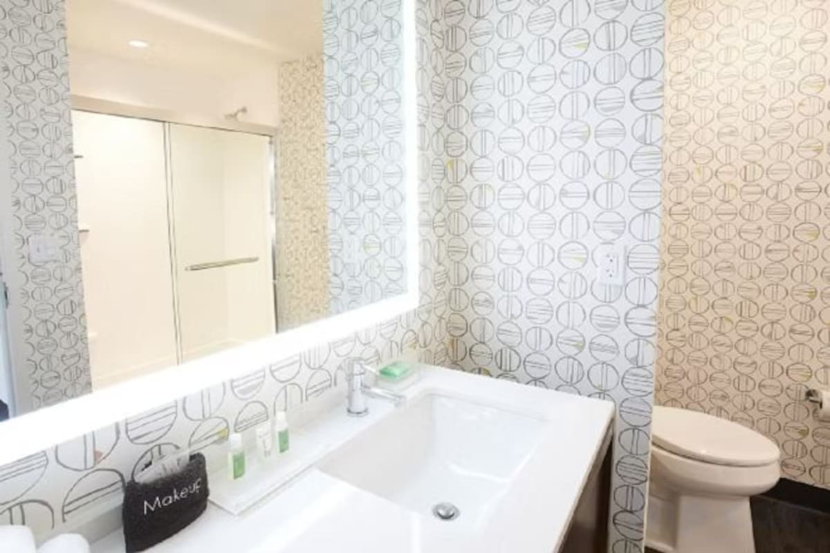 A bathroom with a white sink, a mirror, and a toilet.
