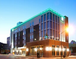 Un hotel Holiday Inn con diseño moderno, que destaca por su entrada con puertas de cristal y fachada de ladrillo.