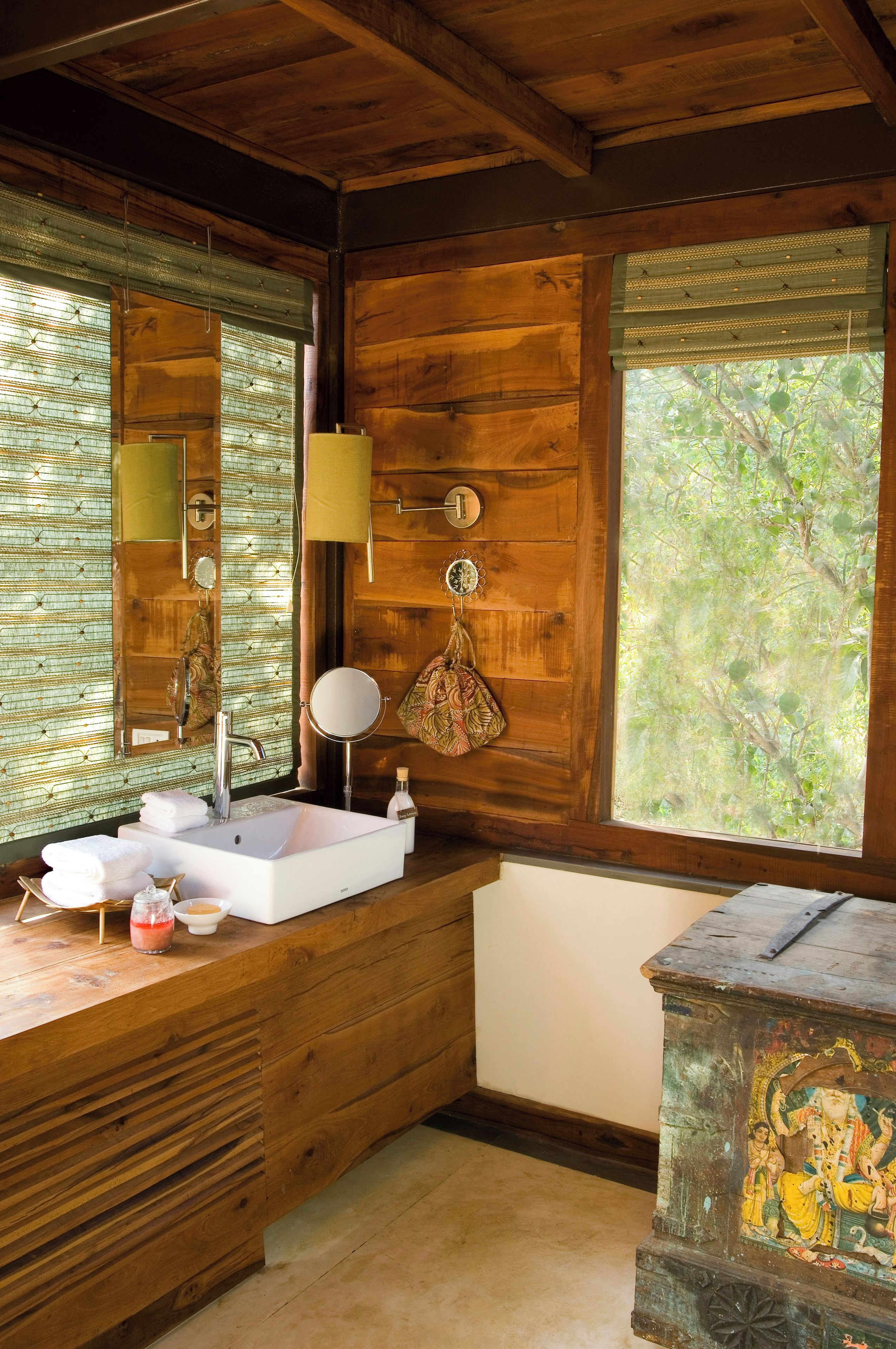 A wooden bathroom with a sink, mirror, and towel rack.
