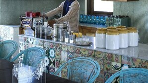 Una cocina con una persona preparando comida, un salpicadero de azulejos y diversos utensilios y recipientes de cocina.
