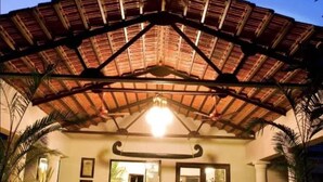 A covered outdoor area with a wooden roof structure and a central light fixture. - Baghvan A Taj Safari Pench National Park (Kurai)