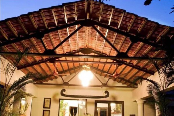 A covered outdoor area with a wooden roof structure and a central light fixture. - Baghvan A Taj Safari Pench National Park (Kurai)