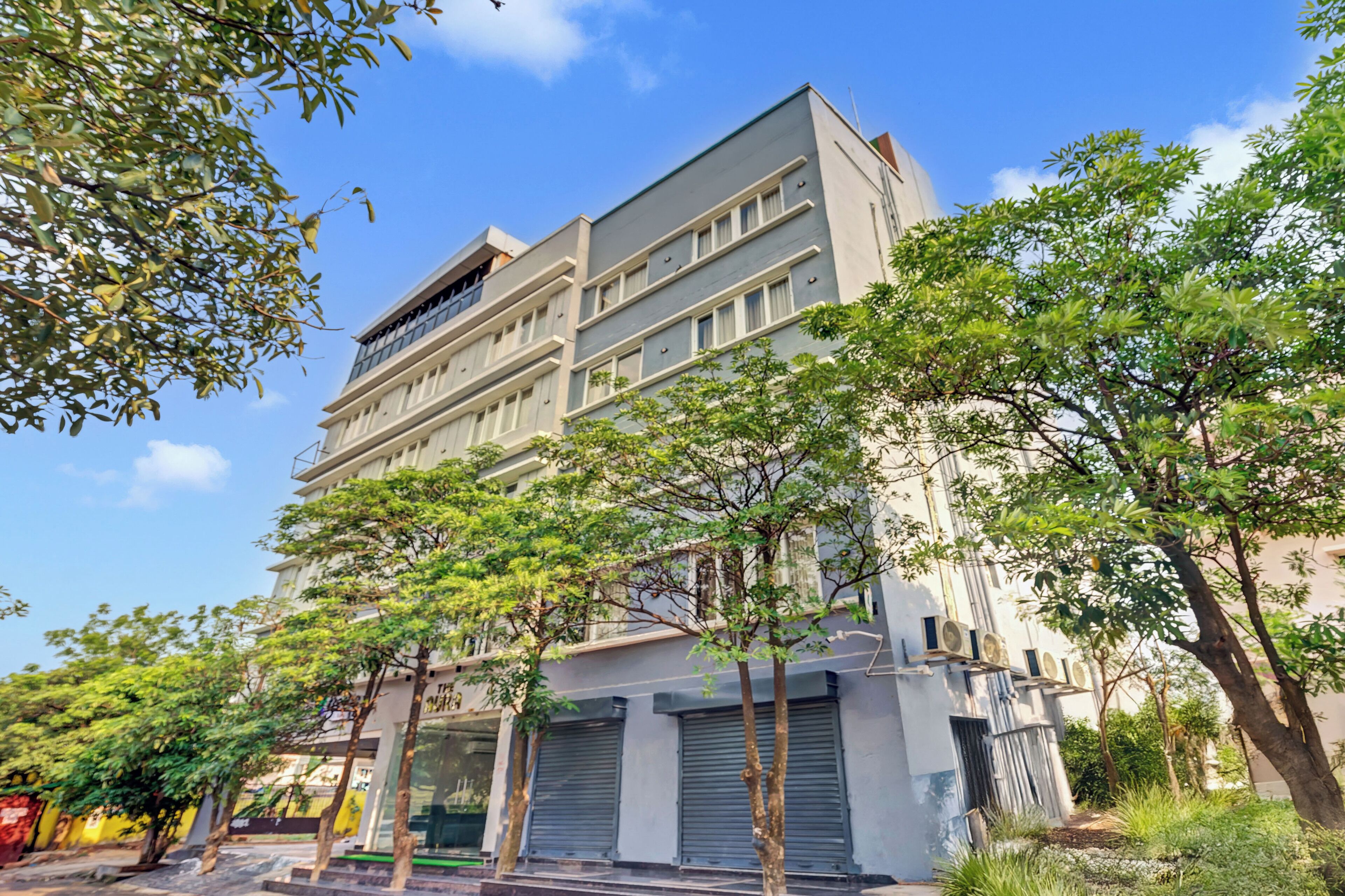 A multi-story building with a modern architectural design, featuring a flat roof and large windows.